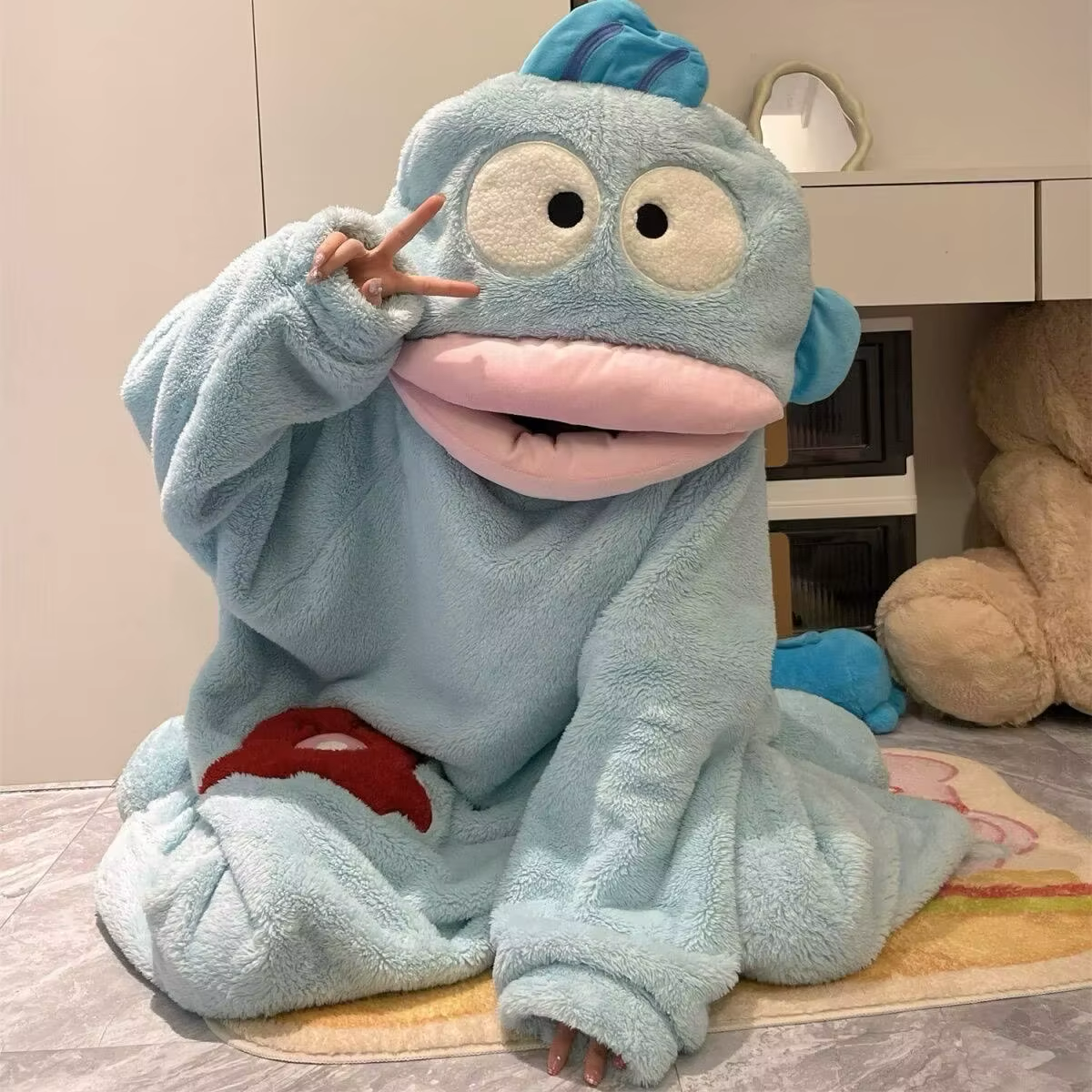 Onzis blue fish onesie worn, peace-sign pose