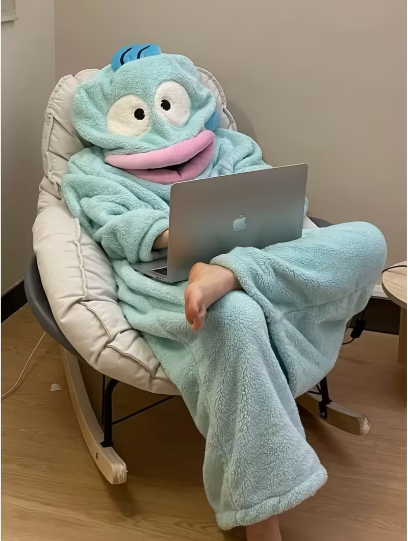 Onzis blue fish onesie worn lounging with a laptop